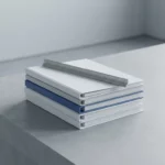 Witte ordners en registersmappen op betonnen bureau met diagonaal geplaatste liniaal in leisteen en saffierblauwe tinten.