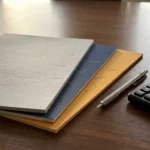 Drie prijsdocumenten van cloudproviders uitgewaaierd op een donkere vergadertafel, met een potlood en rekenmachine ernaast.
