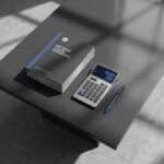 Stapel EA-softwarelicentiedocumenten op bestuurskamertafel met calculator en pen in natuurlijk licht