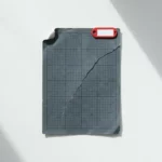 Gekanteld IBM-serverlicentiedocument op wit bureau met rode waarschuwingstag, geometrische schaduwen in leisteen en marineblauw.