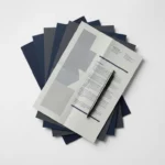 IBM softwarelicentiedocumenten gestapeld op wit bureau met pen, in marineblauw, grijs en wit tinten.