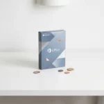 Microsoft Office softwarepakket op wit bureau met verspreide munten, minimalistische compositie met zachte blauwe en zilveren tinten