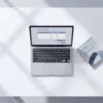Laptop met kostencalculator interface naast Microsoft Office software box op wit bureau, minimalistisch werkplek bovenaanzicht