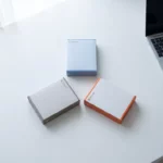 Drie Microsoft Office productdozen in driehoekige opstelling op wit bureau met laptop en zachte natuurlijke belichting