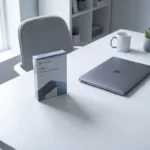 Microsoft Office softwarebox naast laptop op witte bureau met zachte schaduw in minimale kantooromgeving
