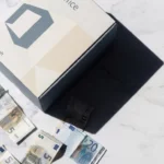 Microsoft Office softwarebox op wit marmeren bureau omringd door verspreide eurobiljetten, overhead perspectief met scherpe schaduwen