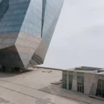 Glazen kantoorgebouw torens boven moderne architectuur in minimalistische stedelijke omgeving met betonnen plein