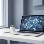 Witte bureau met open laptop die geometrische netwerknodes toont, omringd door pen en kleine vetplant
