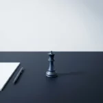 Schaakkoningin op minimalistische onderhandeltafel met document en pen, IBM-blauw en antraciet kleurenpalet.