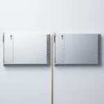 Twee identieke zilveren serverunits naast elkaar op wit oppervlak, gescheiden door een gouden accentlijn, met meetschaal eronder.