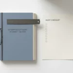 Stapel bedrijfssoftware licentiedocumenten naast een auditchecklist op wit bureau, met geometrische liniaal, bovenaanzicht.