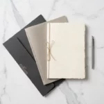 Drie softwarelicentiedocumenten gerangschikt in waaierpatroon op wit marmeren bureau met zilveren pen