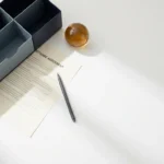 Softwarecontract gedeeltelijk bedekt door een bureauorganizer, met een pen er diagonaal overheen op een wit bureau.